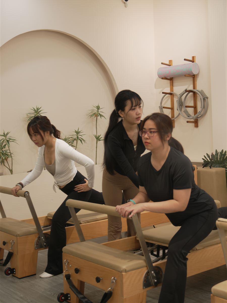 Anh Đào hướng dẫn hai học viên trên máy Reformer